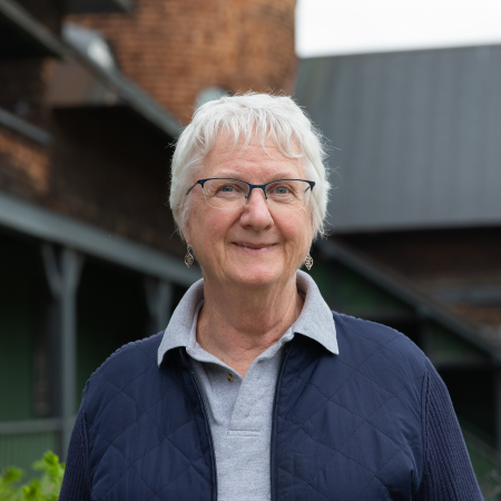 Judy Brook, woman with white hair in blue cardigan