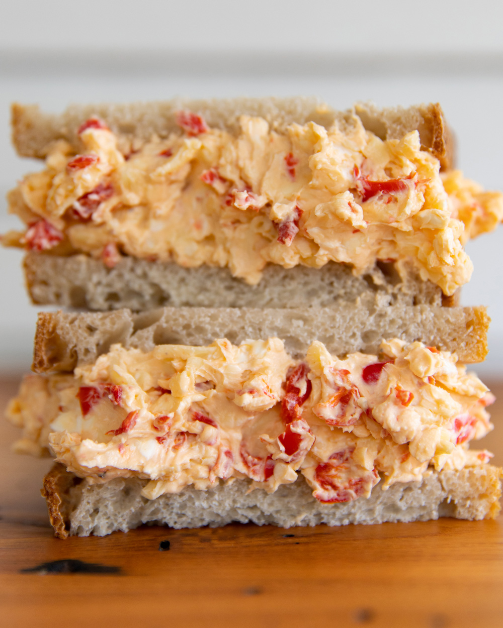 Two halves of a pimento cheese sandwich, stacked on top of one another