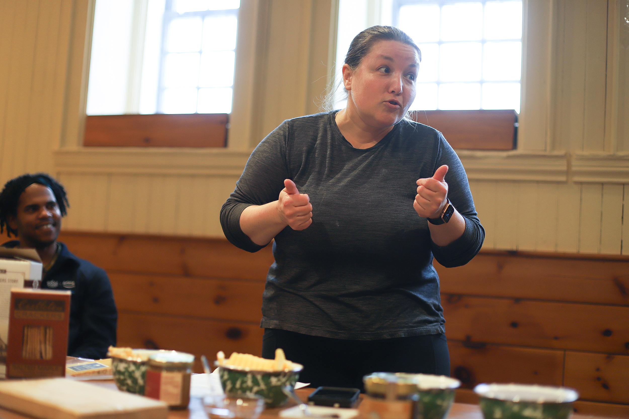 Andi Wandt in gray shirt talking behind table with cheese and pairings on it