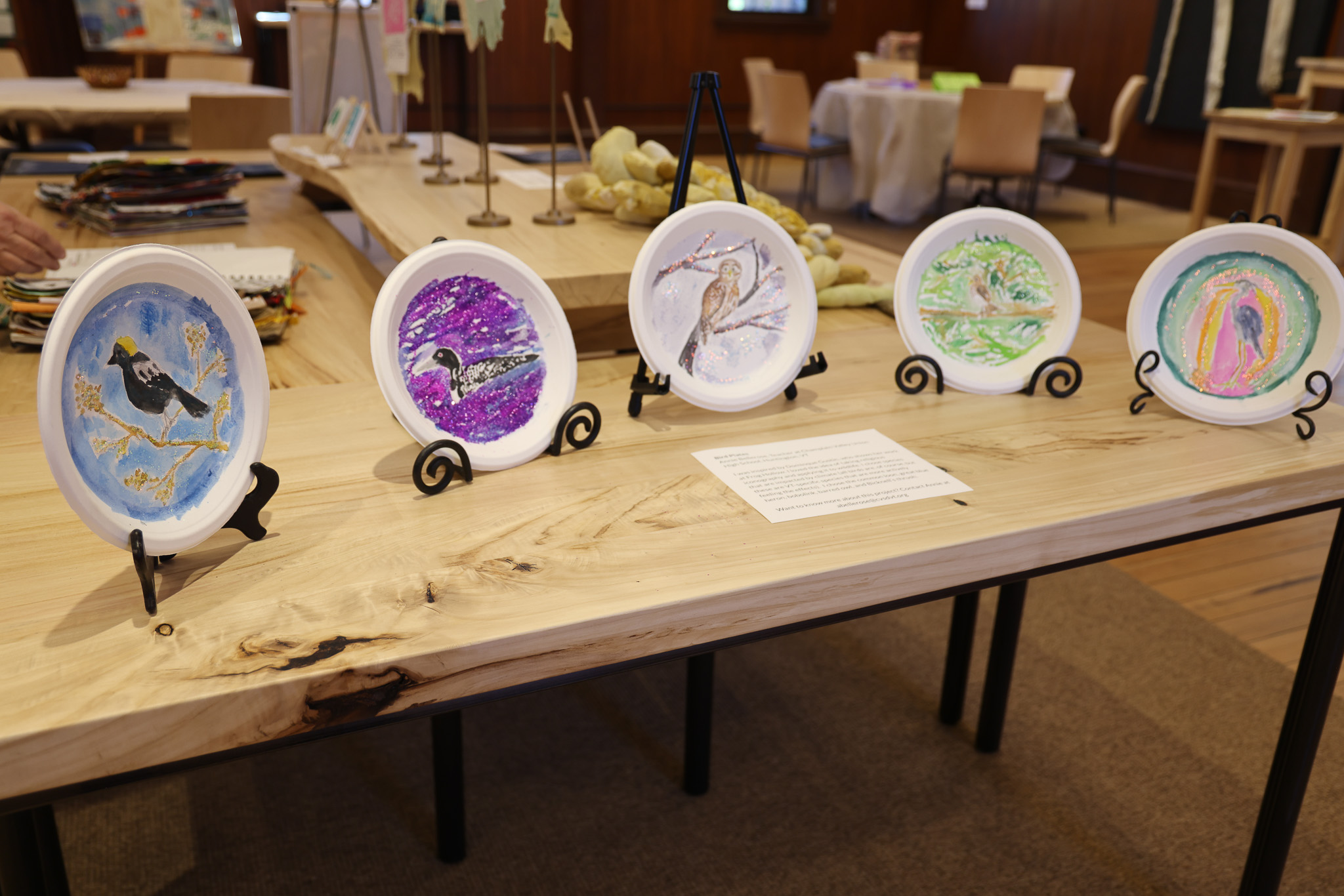 A series of hand painted paper plates depicting birds