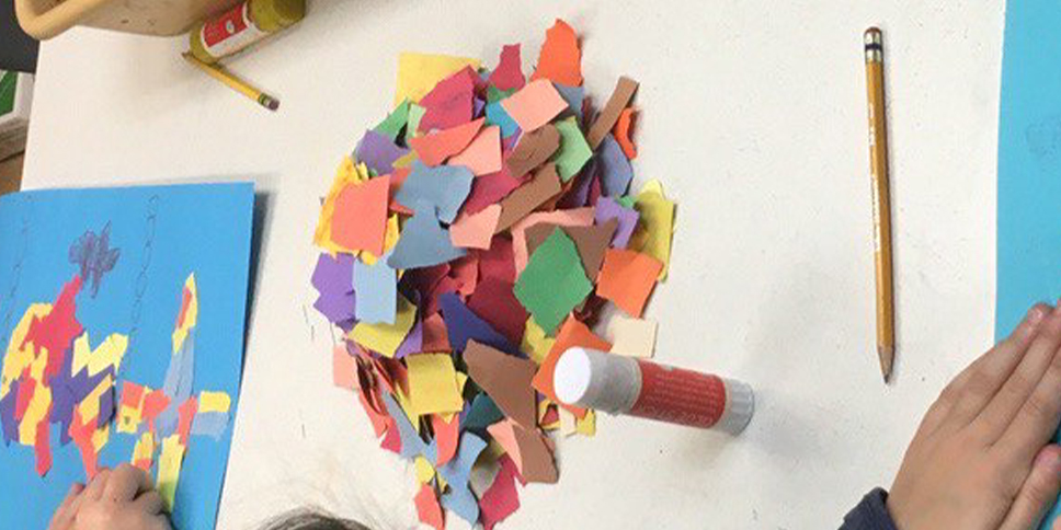 A pile of colorful torn paper on a classroom table