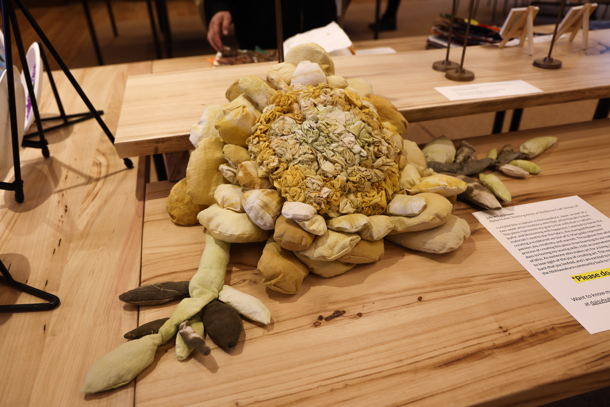 A large flower sewn out of fabric sits on a table