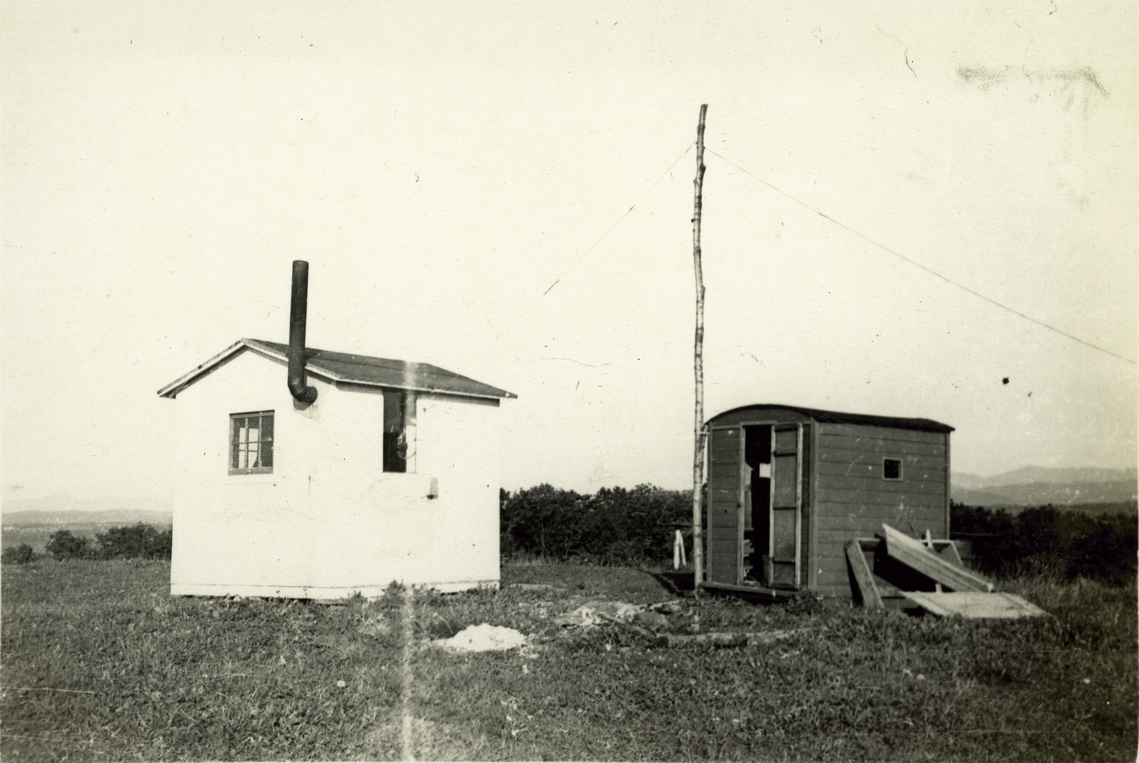 two small shacks on top of a hill