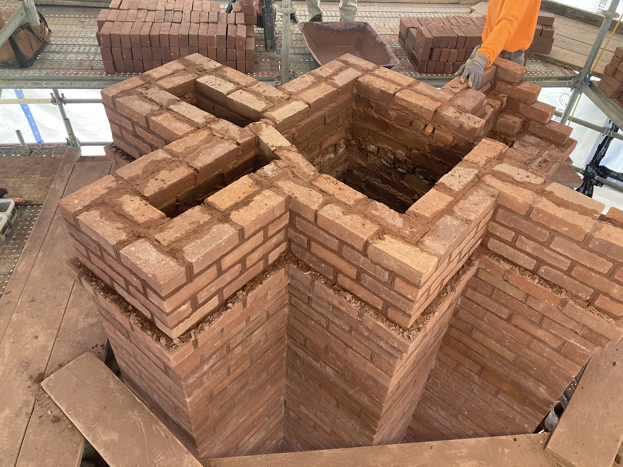 a large brick chimney being reconstructed