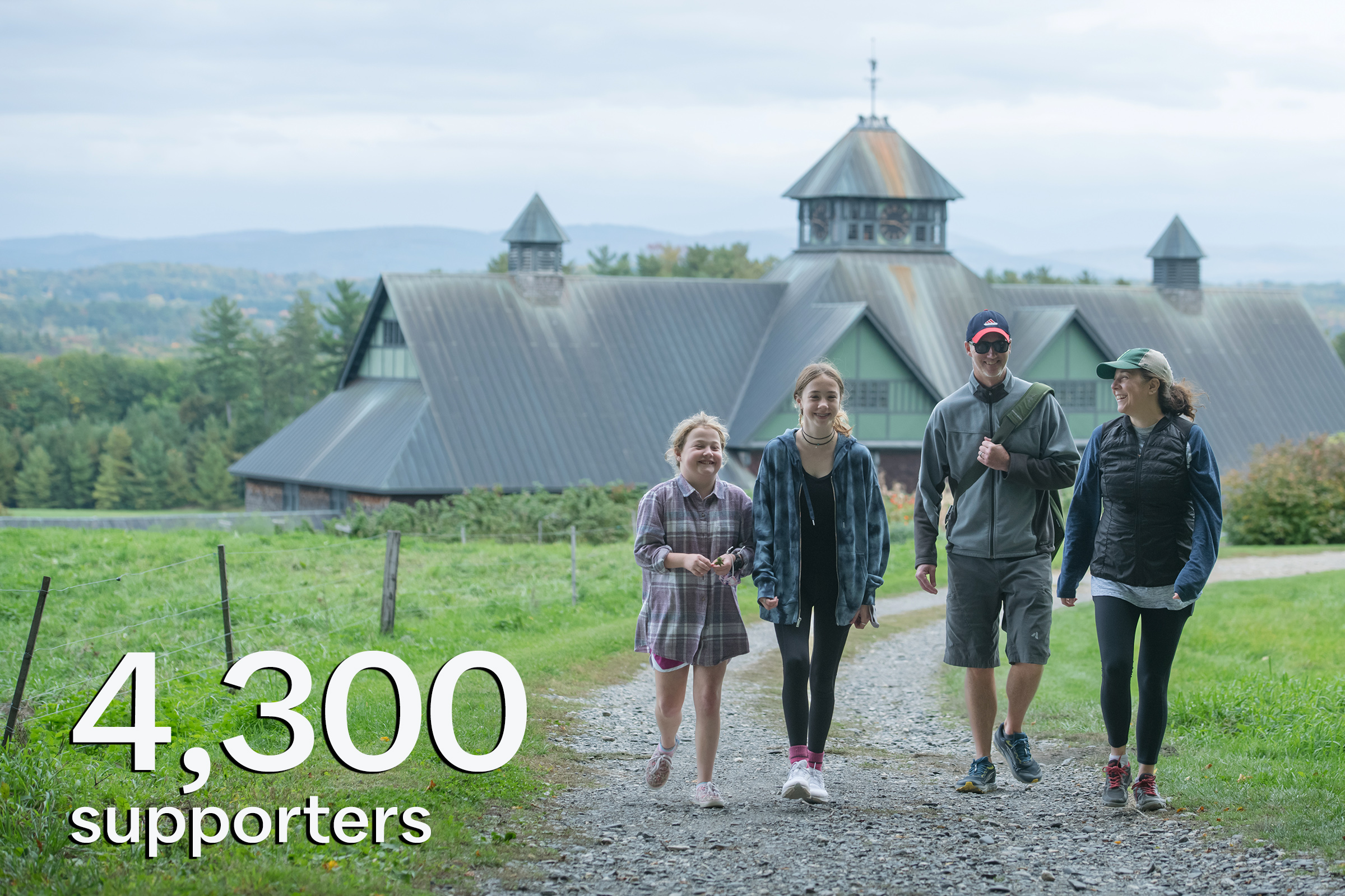 family of four walking on trail with top of Farm Barn behind them