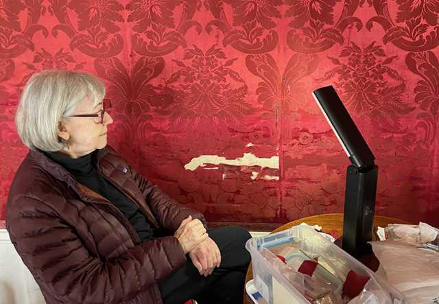 woman sitting beside red wall