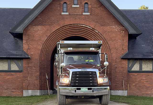 Big one-ton truck backing into archway of the Coach Barn