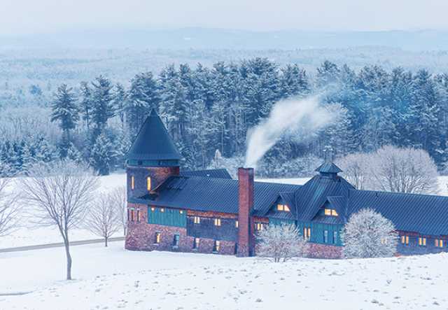 farm barn in snow with window lights glowing