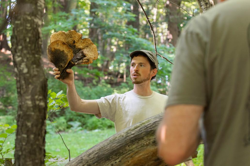 Ari Rockland-Miller holding up a large foraged mushroom