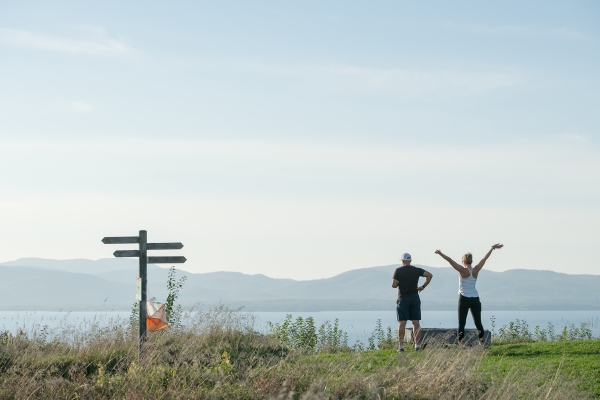 Two people enjoying the view from Lone Tree Hill across Lake Champlain to the Adirondacks