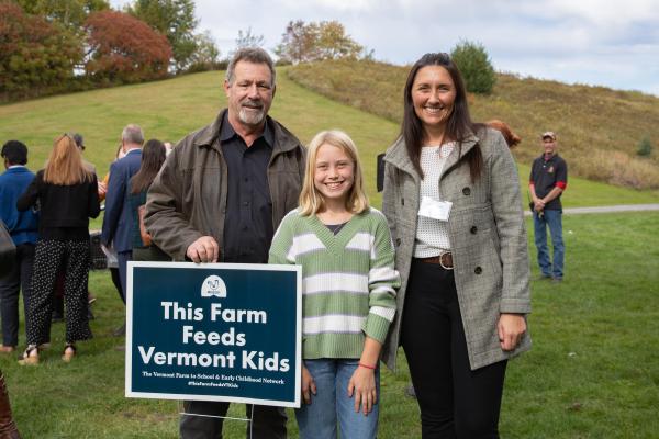 Producer John Farr of Green Mountain Harvest Hydroponics and Harwood Union Unified School District (HUUSD) Schools Food & Nutrition Co-Director Erika Dolan celebrate with a Crossett Brook Middle School student. HUUSD purchases produce from Green Mountain Harvest Hydroponics for their school meal programs, offering students nutritious, local foods.