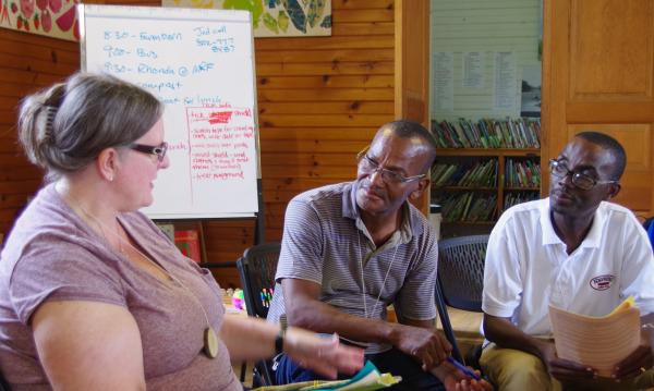 Three people sitting at a table in Haiti