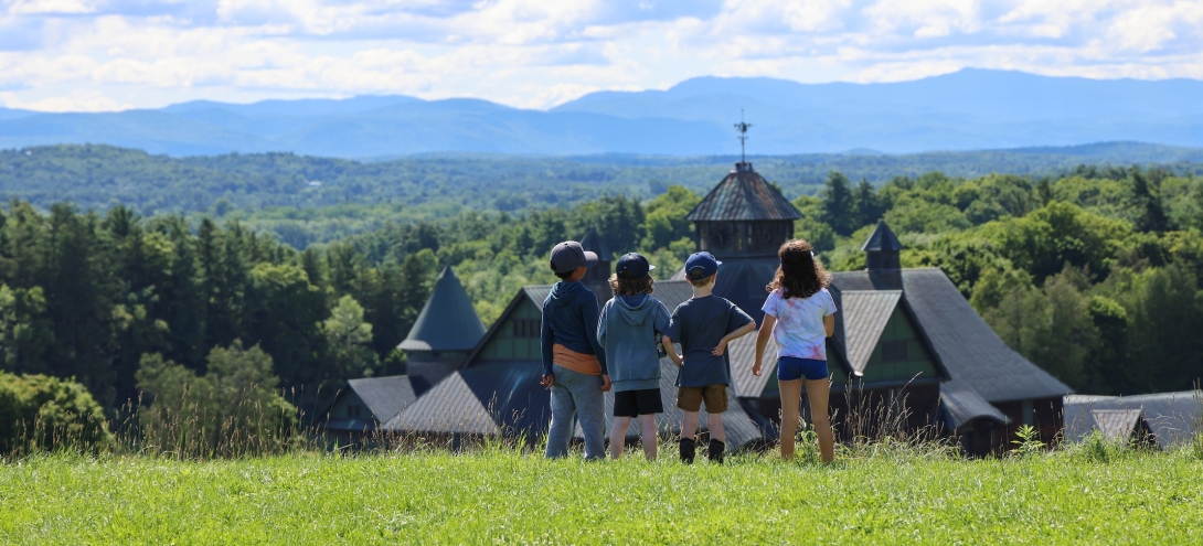 Kids at summer camp looking from a hill at the Farm Barn